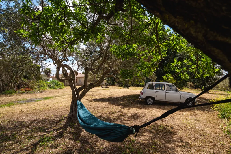Amaca turchese all’ombra degli alberi nella proprietà