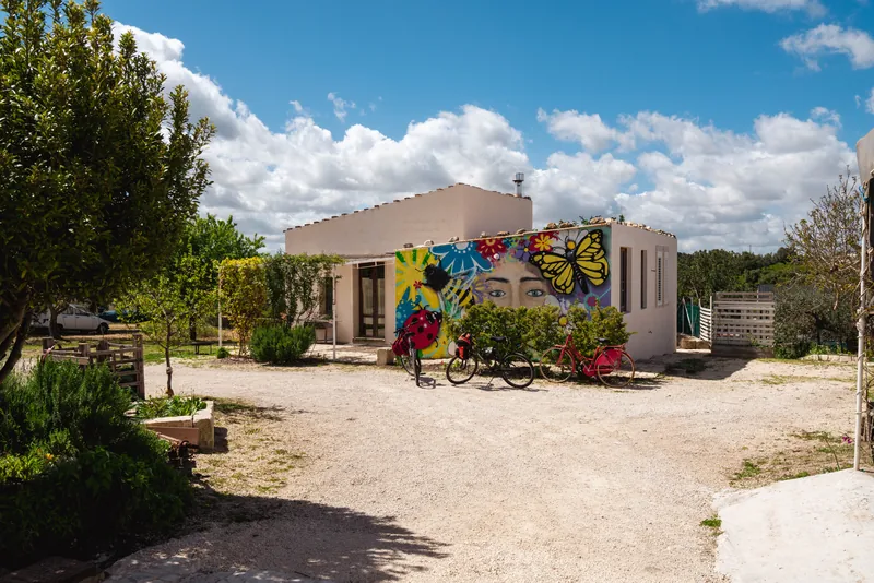 Vista della casa con murale colorato e biciclette davanti all’ingresso